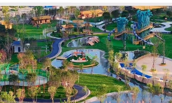 Aerial view of a themed outdoor park with slides, water play and landscape play areas