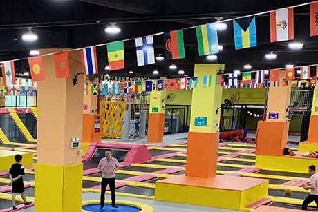 Trampoline park hall with jump courts and guests bouncing