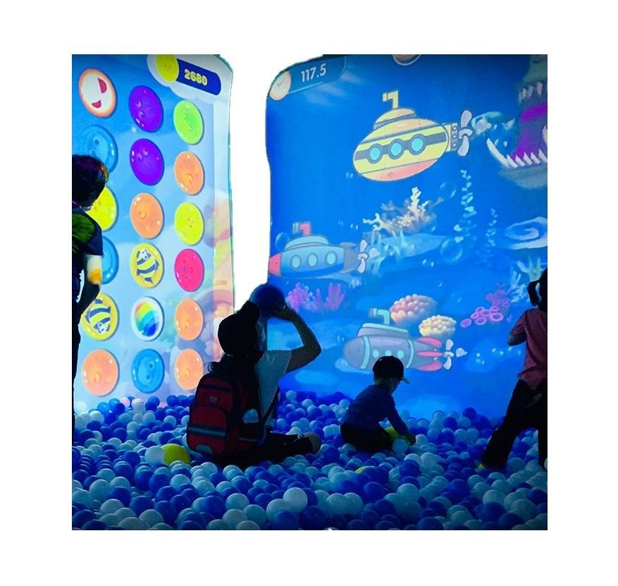 Children playing with an interactive projection floor in a ball pit