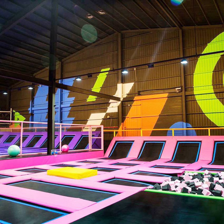 Trampoline park venue with pink courts and party seating